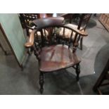 Circa 1830 a broad arm elm captains chair on turned supports with double "H" stretcher