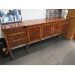 A modern burr wood sideboard, three cupboard doors flanked by six drawers, leg a/f, 214cm long,