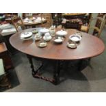 An 18th Century oak gateleg oval top dining table the rising leaves over spiral twist legs and