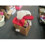 A basket containing an assortment of hats and scarfs including wool examples