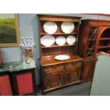 An oak dresser with plate rack back, two drawer on two cupboard door base,