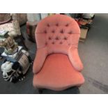 A Victorian button back armchair the serpentine front seat over turned legs and ceramic castors