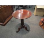 An early Victorian walnut wine table the dished circular top on fluted column and carved scroll