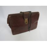 A vintage brown leather briefcase with key,