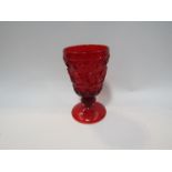 A pressed glass water goblet, the ruby red bowl with raised decoration,