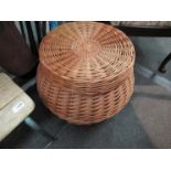 A large modern wicker basket of bulbous form with flat lid,