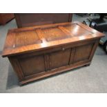 A 17th Century style oak three panel coffer with lined interior and key over stile feet,