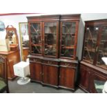 An astragal glazed top over three drawer three door cupboard base bookcase,