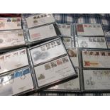 A box containing four albums of first day covers