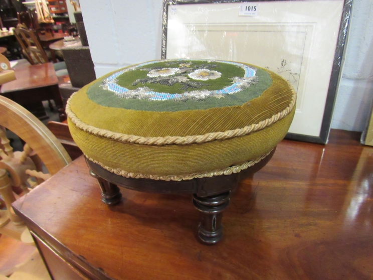 A Victorian walnut circular footstool with floral beadwork upholstery on turned and reeded feet,