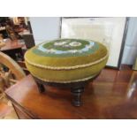 A Victorian walnut circular footstool with floral beadwork upholstery on turned and reeded feet,