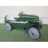 A child's green painted metal pedal racing car