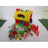 A plastic model barn with a collection of farm animals,