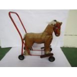 A 1950s Tri-Ang straw filled push along horse,