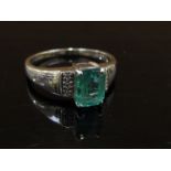 A 9ct white gold ring with emerald, 5mmx 8mm flanked by three round cut diamonds. Size R, 3.