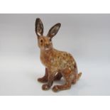A Winstanley brown seated hare, front leg restored,