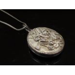 An Indian white metal oval locket depicting fighting Goddess, hung on a chain stamped 925, 28.