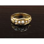 An 18ct gold ring set with five pearls in ornate setting. Size N, 3.