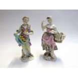 A pair of continental porcelain figures, gentleman with lemons, lady with basket,