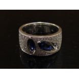 A white gold diamond and sapphire modernist design ring stamped 14K.