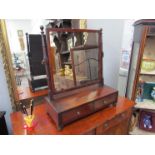 A George III mahogany toilet mirror on ring turned supports with two base drawers on ball feet,