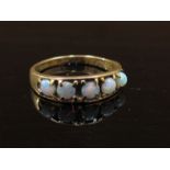 A gold ring set with five circular opals, stamped 375. Size M, 2.