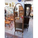 An Edwardian walnut cheval mirror the brass finials over pad foot outswept legs and inverted turned