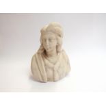 A carved stone bust of female with feather in her hair,