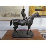 A bronze sculpture of a jockey on horse signed C.