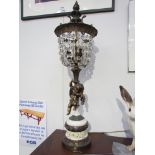 A late 19th/early 20th Century French bronze cherub form figural table lamp with crystal drop shade