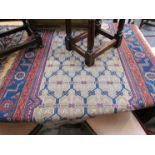 An Eastern wool red ground rug, central lozenge with three rows of guls,