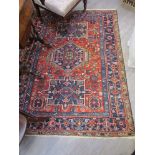 A wool rug with three central lozenges, multiple borders and tasselled ends,