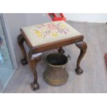 An early 20th Century ball and claw footstool with tapestry top,
