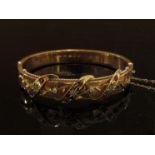 An Edwardian 9ct gold ornate bracelet set with diamonds and rubies with leaf and ribbon decoration