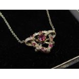 A ruby and diamond heart shaped pendant on chain,