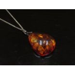 A Baltic amber pendant with seed inclusions 6.