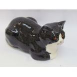 A Winstanley recumbent black and white cat, 19cm tall,