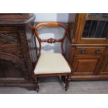 A set of four William IV mahogany balloon back chairs with carved back rail over turned and