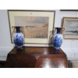 A pair of blue and white vases with gilt handles,