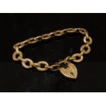 A 9ct rose gold engraved heart padlock on oval link bracelet,