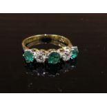 An emerald and diamond five stone ring, stamped 750/plat, .40ct diamond, .90ct emerald.