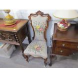 A Victorian rosewood nursing chair with tapestry upholstery,