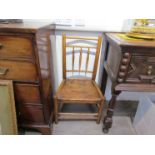 An early 19th Century elm seated child's chair with turned spindle back support