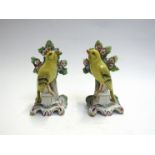 A pair of late 19th Century Bocage yellow Canary figures, damage to leaves,