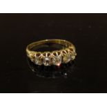 An 18ct gold (marks rubbed) five stone old cut diamond ring. Size O, 3.