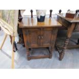 A 20th Century oak two door bedside cabinet with carved doors,