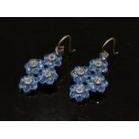 A pair of costume earrings with blue and white flowers, gold posts,