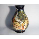 A Moorcroft Carp pattern vase, three carp to foliate blue ground, designed by Philip Gibson 2002,