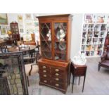 A slim Georgian mahogany glazed bookcase on four drawer base with slide,