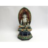 A ceramic shrine figure of a Buddha,